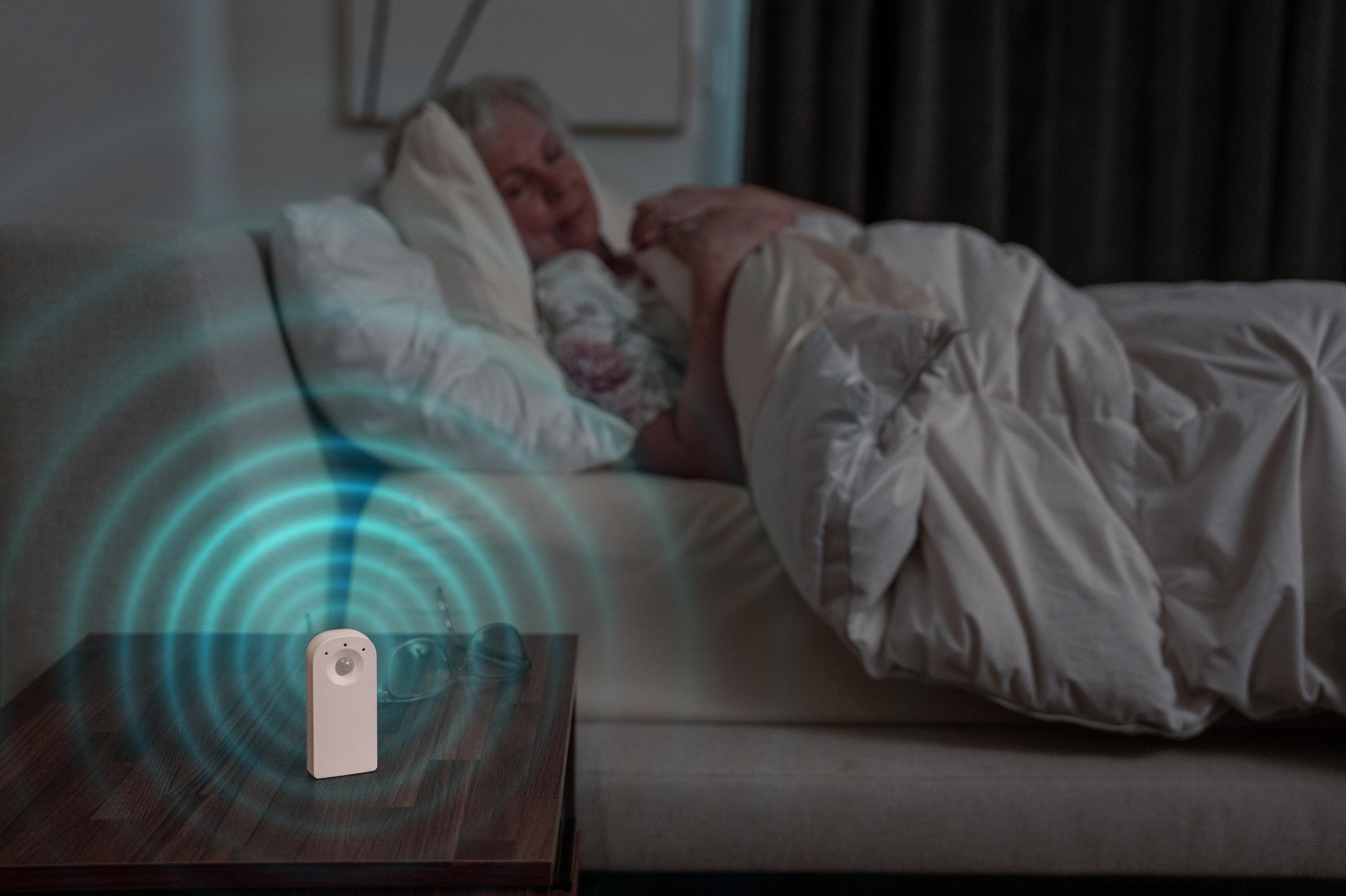 device ringing on night stand next to woman in bed