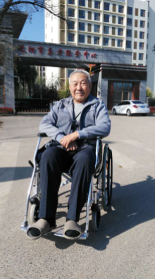 man in wheelchair smiling on the street