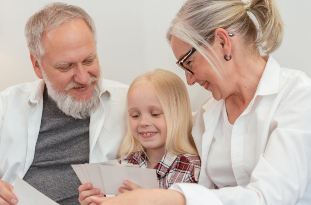 two adults looking at pictures with little girl