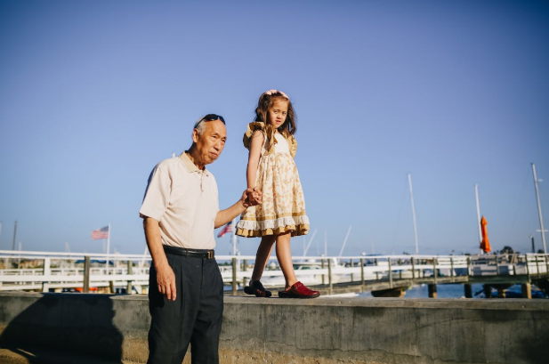 man walking with little girl on bay edge