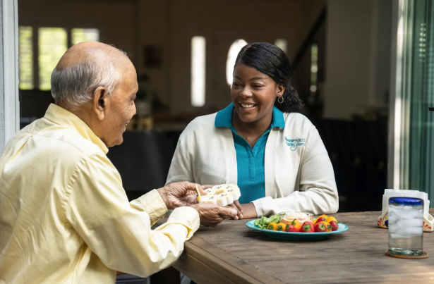man getting pills out of container and smiling at caregiver